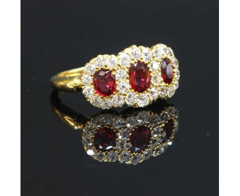 An Edwardian ruby and diamond triple cluster ring, c.1900, with three oval mixed cut rubies, grain set to the centres. All su