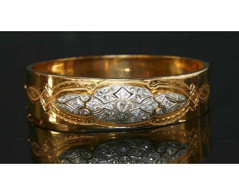 A French diamond set platinum and gold hinged bangle, with an Art Deco diamond set centrepiece. The stepped centrepiece with 