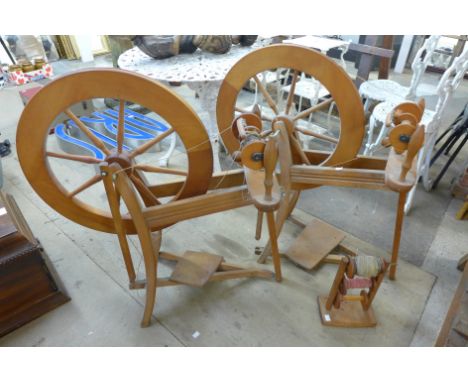 Two wooden spinning wheels and a bobbin stand 