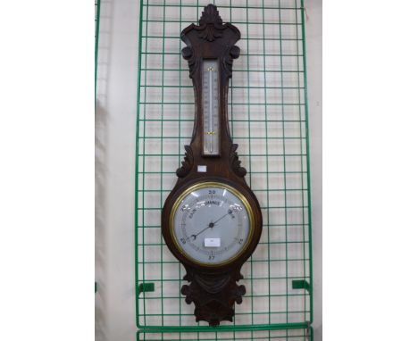 A carved oak aneroid barometer 