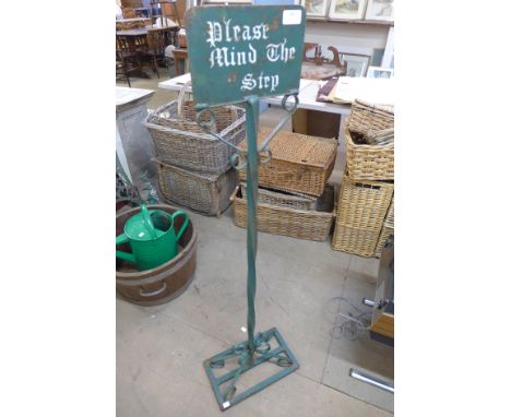 A cast and wrought iron Please Mind the Step sign 