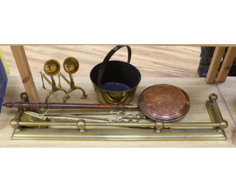Brassware including fire kerb, fire tools, arts and crafts fire dogs and a copper warming pan, the largest 116cm wide