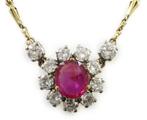 A modern 9ct gold, single stone oval cut ruby and eleven stone round cut diamond cluster set pendant necklace, 39cm, gross we