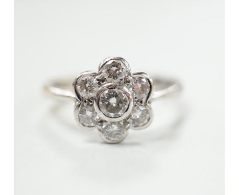 A modern 18ct white gold and seven stone diamond set flower head cluster ring, size O, gross weight 4.5 grams.