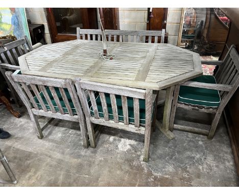 An Alexandra Rose weathered teak octagonal garden table, length 210cm, width 122cm, height 74cm, a bench, four elbow chairs w