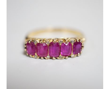 An early to mid 20th century 18ct and graduated five stone ruby set half hoop ring, with diamond chip spacers, size L, gross 