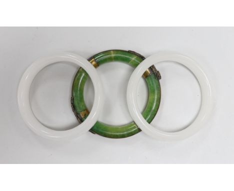 Three Chinese bangles, two in white and one in green with applied brass ring and dragons