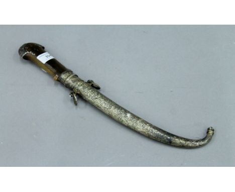 An antique horn (possibly rhino) handled jambiya in unmarked white metal scabbard. 38.5 cm long. 