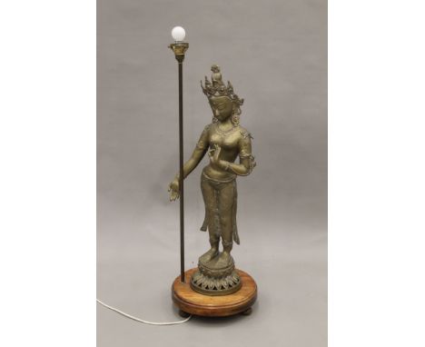A floor lamp set with a brass model of Guanyin. 107 cm high overall.