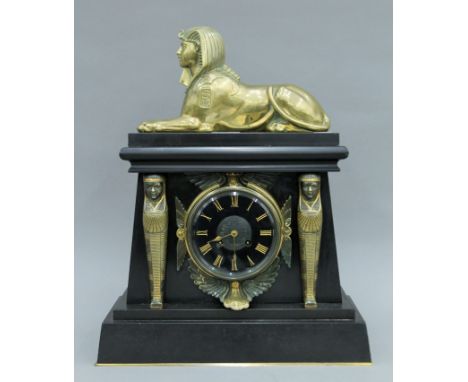 A 19th century black marble mantle clock decorated in the Egyptian revival manner. 46 cm high, 16 cm deep, 36.5 cm wide.