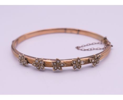 An unmarked gold seed pearl set bangle form bracelet. 6.5 cm wide. 7.3 grammes total weight.