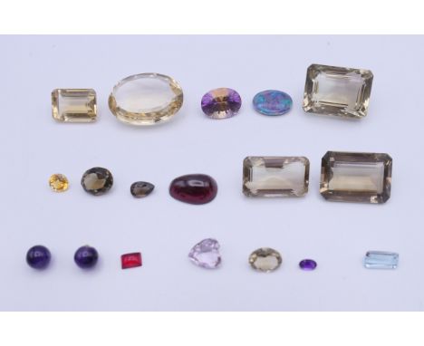 A box of loose gem stones, including opal, quartz, amethyst, etc. The largest 3 cm long.