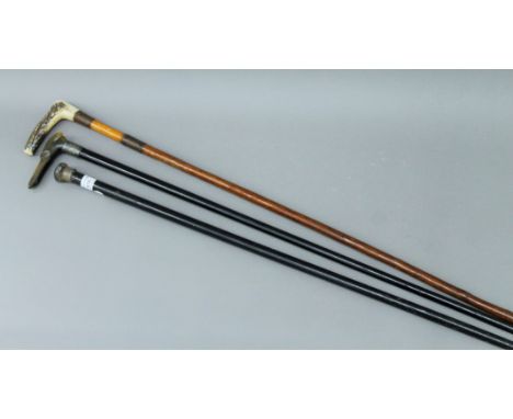 Three walking sticks - one with silver finial, one with horn handle formed as a greyhound and the other with antler handle. T