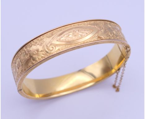 A gold plated bangle form bracelet. 6.5 cm wide.