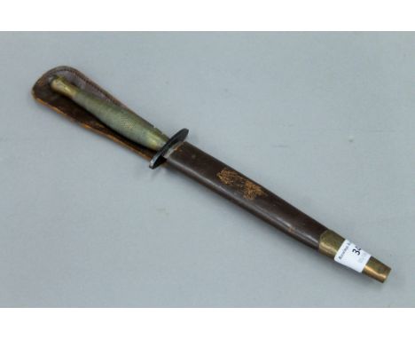 A Fairbairn-Sykes fighting knife in leather scabbard. 31.5 cm long.