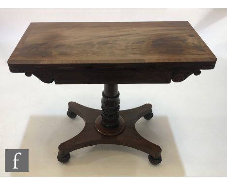 A 19th Century crossbanded rectangular fold over card table on turned carved pedestal and quatrefoil base, on reeded turned f