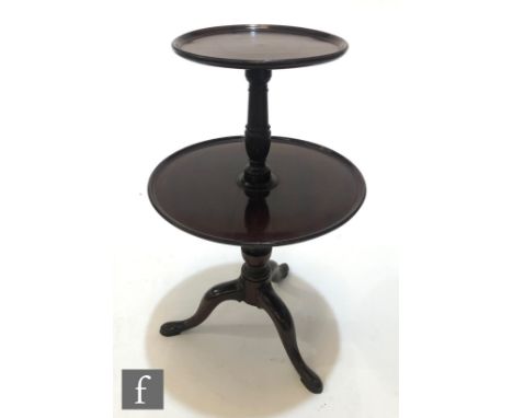 A George III style mahogany two tier dumb waiter, the smaller fixed dished top over a revolving centre tier, on turned pedest