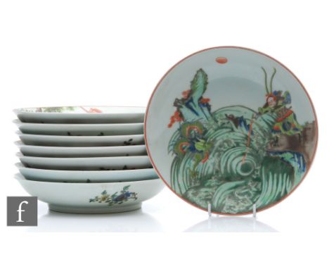 A set of eight Chinese famille verte dishes, each of circular form, the shallow well of each decorated with a different depic