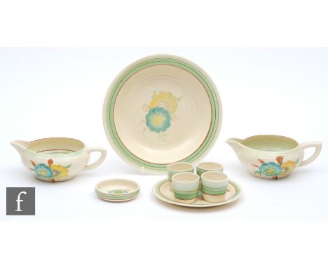 A Clarice Cliff egg cup set circa 1936,&nbsp;hand painted with flower heads with green and brown banding, together with two s