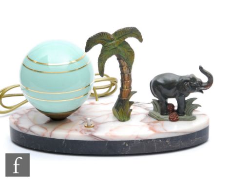 A 20th Century table lamp, decorated with a painted spelter stylised standing elephant beside a palm tree, with spherical pal