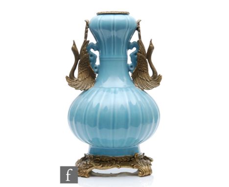 A Chinese Robin's Egg blue porcelain vase of bottle form, rising to a garlic head, applied with relief carved dragon handles 