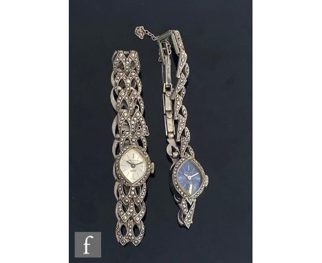 Two hallmarked silver and marcasite set Delvina manual wind wrist watches, one with a silvered dial, one with a blue dial. (2