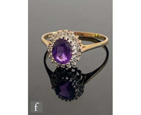 A 9ct hallmarked amethyst and diamond cluster ring, central oval amethyst within an eighteen stone diamond surround, all to k