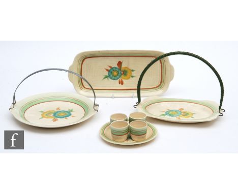 A Clarice Cliff egg cup set circa 1936,&nbsp;hand painted with flower heads with green and brown banding, together with a san