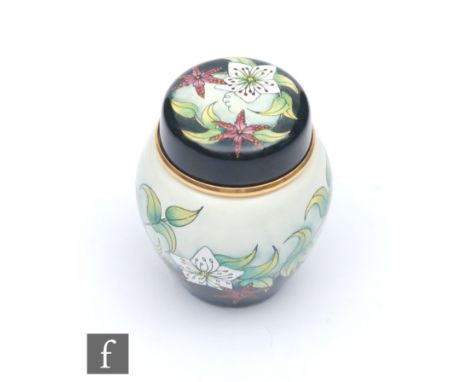 A Moorcroft Enamel ginger jar and cover decorated with a hand painted floral pattern, printed mark, height 5cm. 