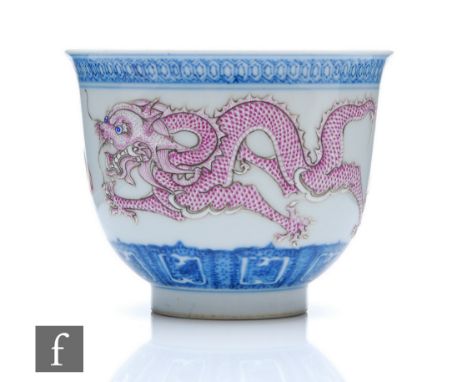 A Chinese late Qing Dynasty blue and white porcelain dragon bowl, the 'U' form bowl rising from a high footring, decorated wi