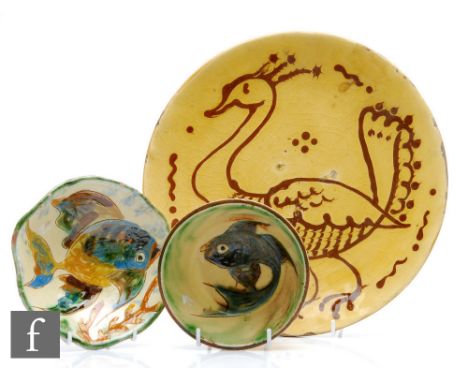 An early to mid 20th Century shallow dish slip decorated with a bird in brown against a mustard yellow ground, unmarked, diam