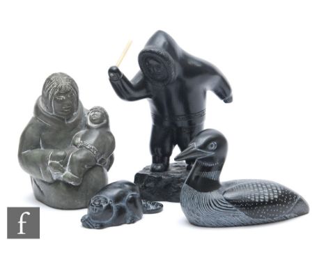 A group of four Boma carved ebonised figures, one of an Eskimo with a child, another figure standing holding a stick, also fi