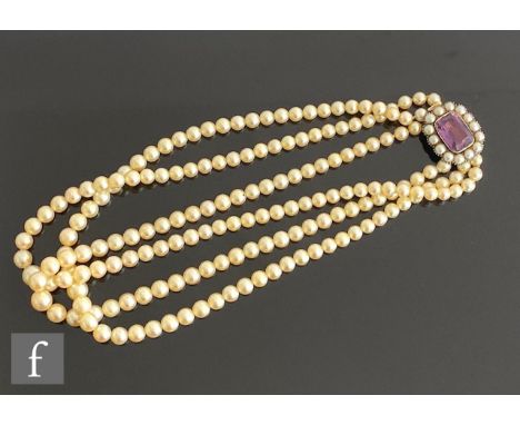 A graduated three row cultured pearl necklet, largest approximately 9mm, terminating in a gold amethyst and split pearl clasp