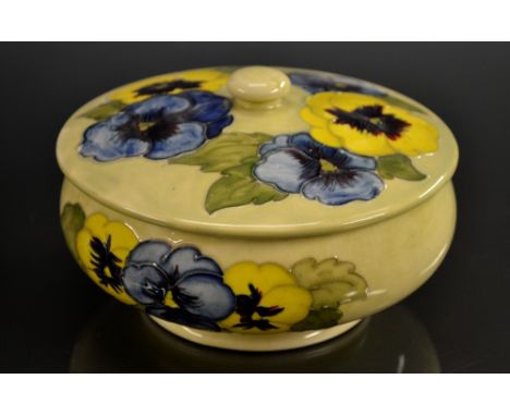 A Moorcroft Pansy pattern powder bowl and cover, tube lined with flowers in yellow and blue on a mottled yellow ground, butto