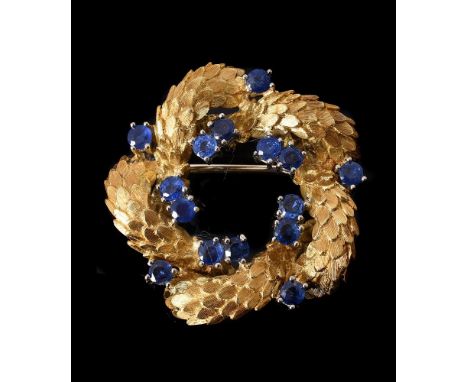 A 1970S SAPPHIRE CIRCLET BROOCHthe interwoven looped scaled textured panels with circular cut sapphire accents, stamped 18K w