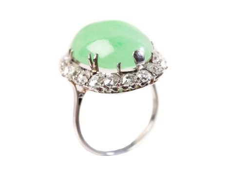 A MID 20TH CENTURY JADEITE AND DIAMOND CLUSTER RINGthe oval cabochon jadeite within a surround of old cut diamonds, approxima