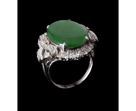 A JADEITE JADE AND DIAMOND CLUSTER RING the oval cabochon jadeite jade panel within a surround of eight cut and baguette cut 