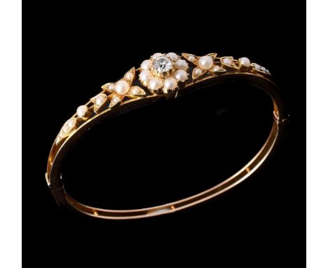 AN EDWARDIAN DIAMOND AND HALF PEARL HINGED BANGLE CIRCA 1910the gold bangle with a central half pearl and old mine cut diamon