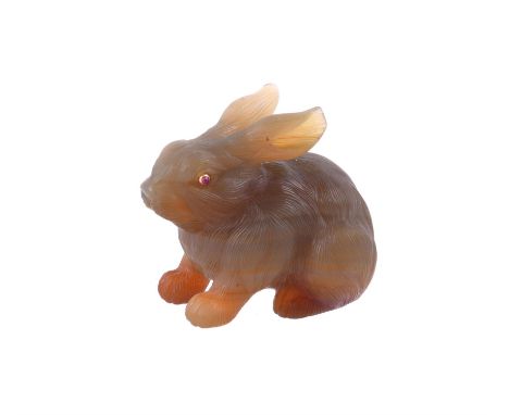 A CARVED AGATE RABBITUnmarked, possibly Russian, the seated agate rabbit with textured coat, with collet set cabochon ruby ey
