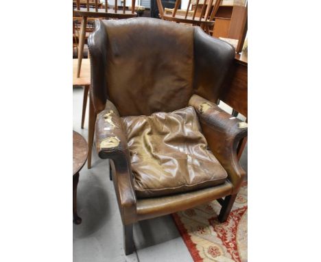 A vintage leather wing armchair