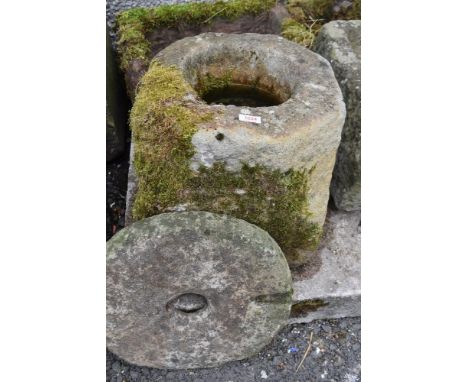 A hand carved stone planter or water trough with grinding stone