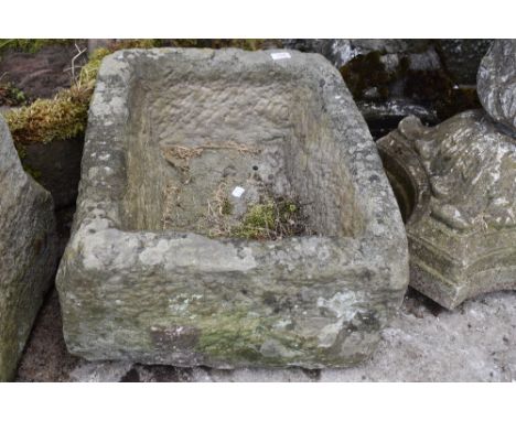 A stone carved planter having holes to base