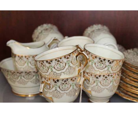 ATTRACTIVE GILT TUSCAN TEA SET
with elaborate gilt, green and red foliate design on a cream ground, with eleven cups, saucers