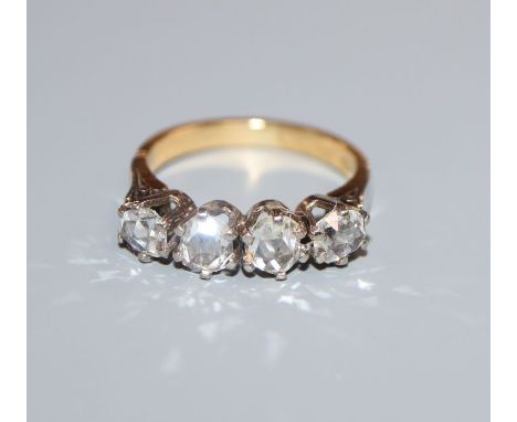 A continental 750 yellow metal and rose cut diamond set four stone half hoop ring, size K.