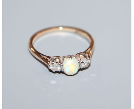 An '18ct and plat', white opal and diamond three stone ring, size K/L.