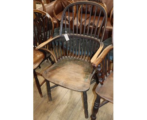 An early 19th century Windsor comb back elbow chair, with traces of original paint