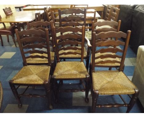 A Set of Six Rush Seated Ladder Back Dining Chairs Including One Carver.