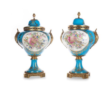 PAIR OF RUSSIAN PORCELAIN LIDDED URNS IN THE MANNER OF SEVRES, 20TH CENTURY with gilt metal mounts, painted with reserves of 