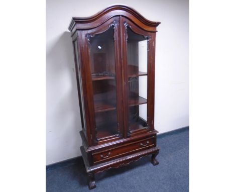 A reproduction double door arch topped display cabinet fitted a drawer on claw and ball feet 