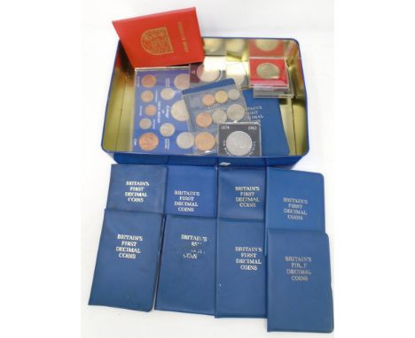 A tin containing assorted coinage including crowns, Britain's first decimal coin set, coinage of Great Britain 1967 etc.